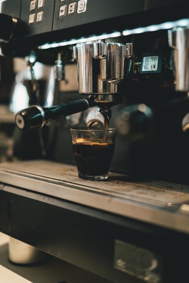 brygning af moerkristetkaffe i glas paa dalla corte espressomaskine