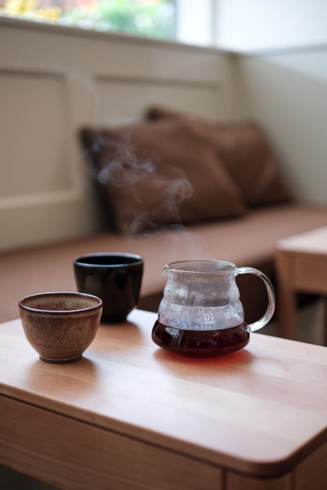 Kaffeservering i glaskande og keramikkopper på bord